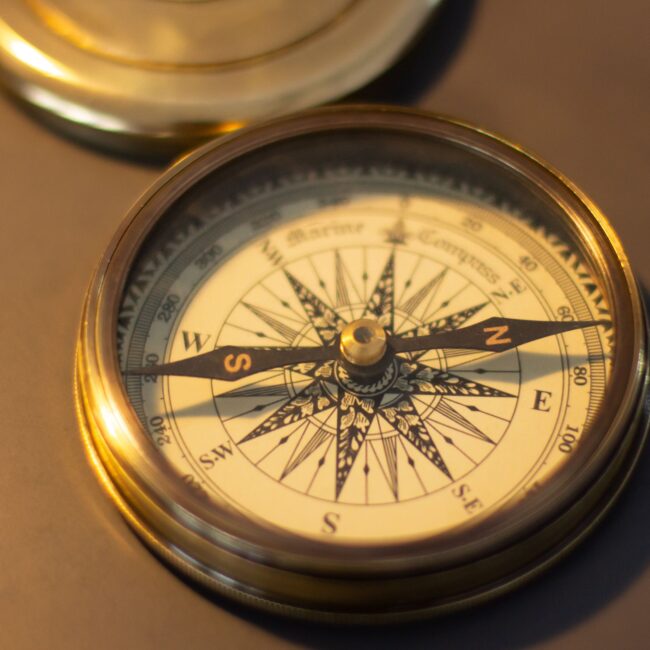 Close-up of a vintage brass compass, emphasizing its nautical design and retro charm.